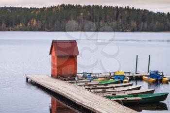 Small red barn on floating pier with moored row boats, Karelia, Russia