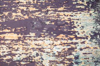 Grungy wooden background with old peeling colorful paint layers