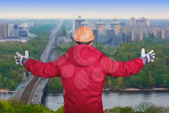 Worker with his arms raised on a cityscape background