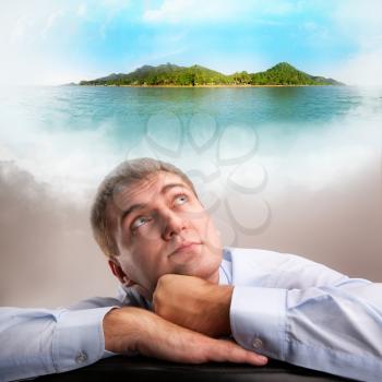 Tired office worker daydreaming about tropical vacation