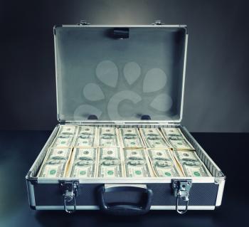 Open case full of dollar cash on gray background