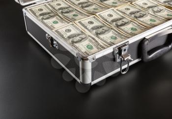 Case full of money isolated on gray background