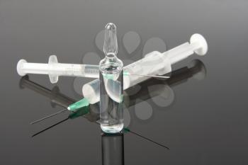 Medicine and two syringes on gray surface