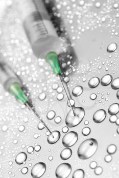 Two medical syringes and water drops