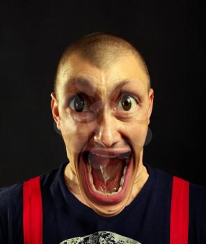 Portrait of very surprised screaming man with giant eyes and open mouth