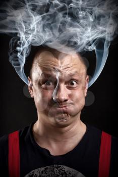 Stressed man with waving smoke from ears