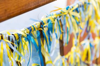 Many Ukrainian blue-yellows fabric ribbons knoted on the bridge