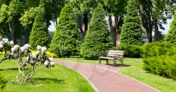Bench in the park and curved stone brick path