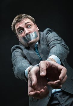 Man with mouth and hands  covered by masking tape, studio shoot