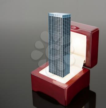 High office building in red jewelry box over grey background