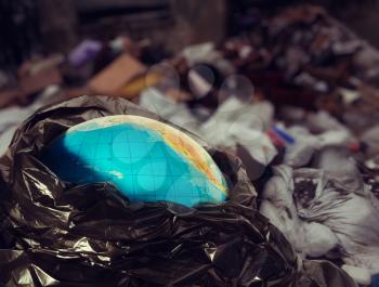 Earth contamination concept. Earth globe in trash