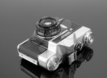 Old photographic camera on gray reflective surface