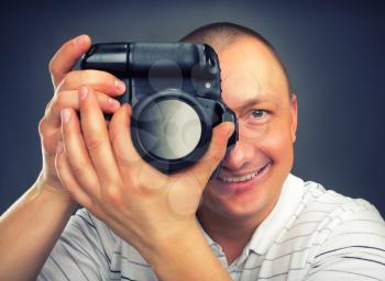 Portrait of smiling photographer holding digital camera