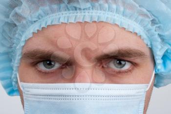 Portrait of serious surgeon in surgical mask and hat