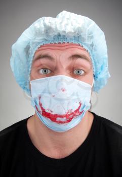 Surprised mental sick blood soiled surgeon in mask