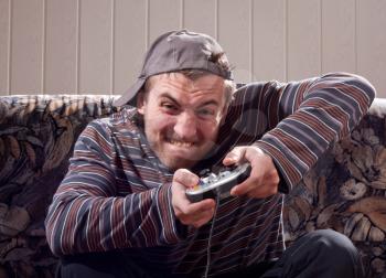 Excited man with joystick playing video games at home