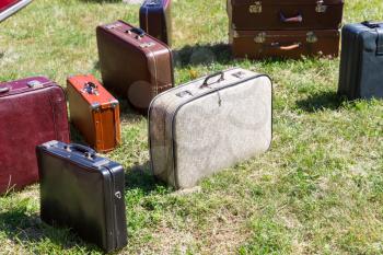 Many old suitcases standing on the grass