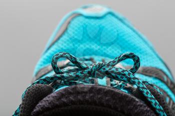 Closeup of blue shoelaces on grey