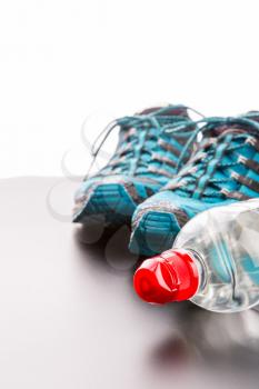 Closeup of runners and a bottle of water on grey background