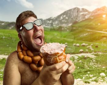 Hungry man with sausages round his neck eats one more sausage in the mountains