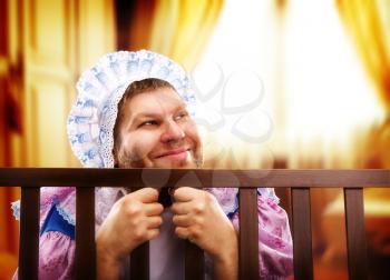 Funny man weared as baby in playpen looking out