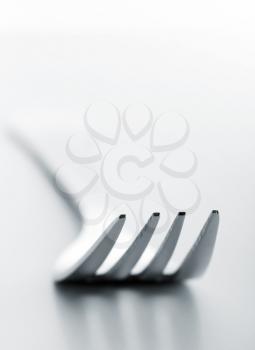 A closeup of silver fork on white background