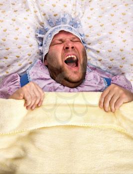 Man weared as baby crying  in bed