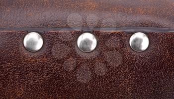 Close-up of metal rivets on leather briefcase