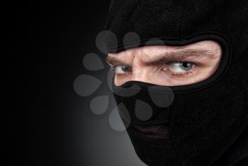 Portrait of man in a mask on black background