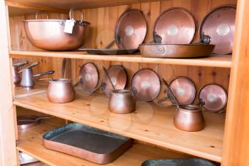 Set of old ibriks and pans on the wooden shelf
