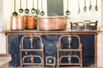 Retro kitchen interior with old pans, pot on the furnace 