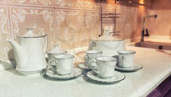 White cups of tea with a teapot and sugar-bowl