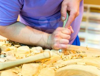 Carving tools with billets in man's hand, close up