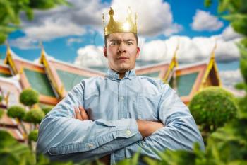 Powerful man wearing crown on the head with crossed hands as a king