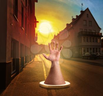 Human hand in the coin in the town while the sunset