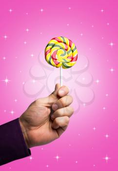 Colorful sweet lollipop in male hand