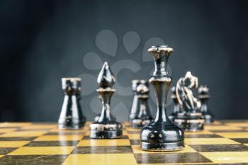 Old wooden chess figures on the board