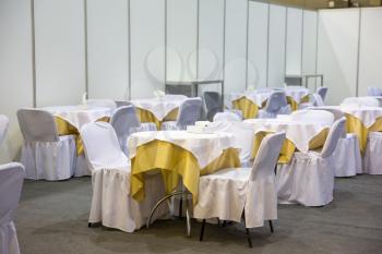 Festive tables and chairs with white cloths in the hall
