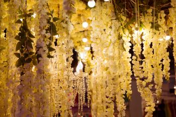 Outdoor hall decorated with branches of flowers and lights
