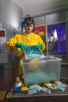 Man in protective suit cooking meth in the lab