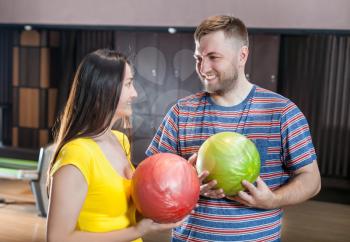 Smiling couple with bowling balls