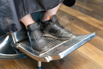 Close up of man's legs in barber chair