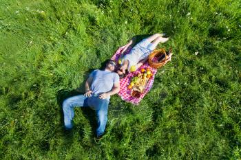Top view of young couple lying on the blanket during picnic