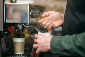 Closeup hands of man who pours coffee from a coffee machine