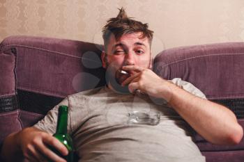 Alcohol addicted man in depression. Drunk man smoke cigarette.