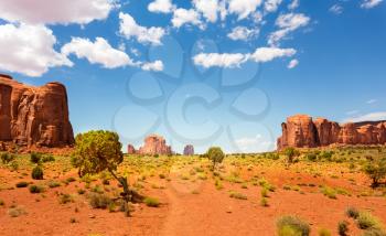 Desert valley and sandstone mountains against cloudy sky at Monument Valley National Tribal Park, Navajo, Utah USA