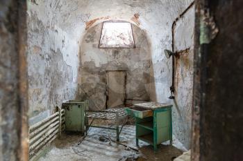 Jail interior with grunge rusty cell and brick walls