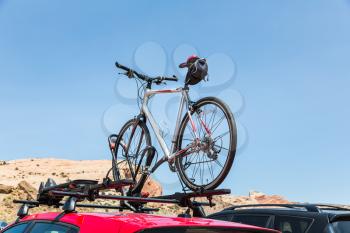 Car is transporting bicycle on the roof. Bike on the trunk