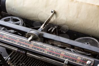 Vintage typewriter ribbon mechanism with inserted old paper closeup.  
