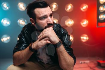 Male performer on the stage with the decorations of lights